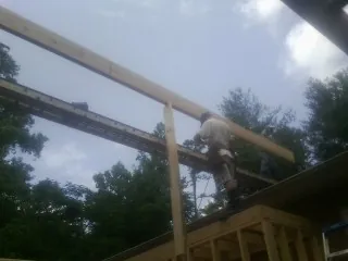 Carpenter setting a ridge beam over a new addition frame — Ice Dam Removal by Roofing Brothers in Forked River