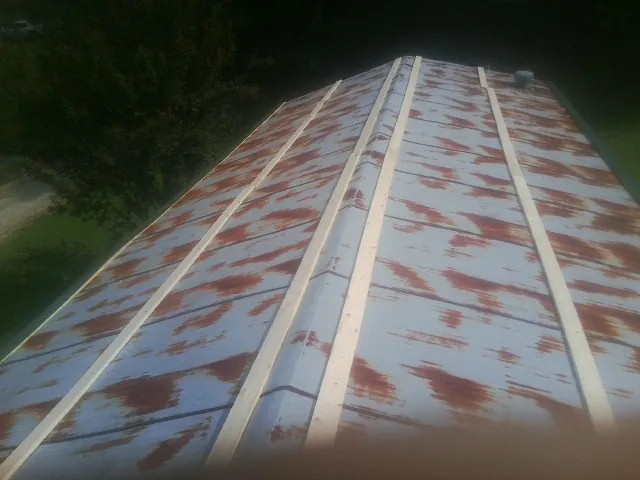 Rusted metal roof panels with new wood purlins before replacement — Storm Damage Roof Repair in Forked River by Roofing Brothers