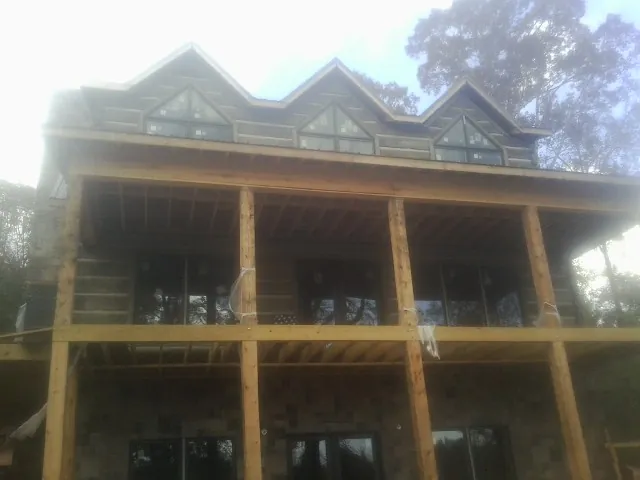 Dormers and porch framing on a large log home under construction — Roof Coating work by our crew in Forked River