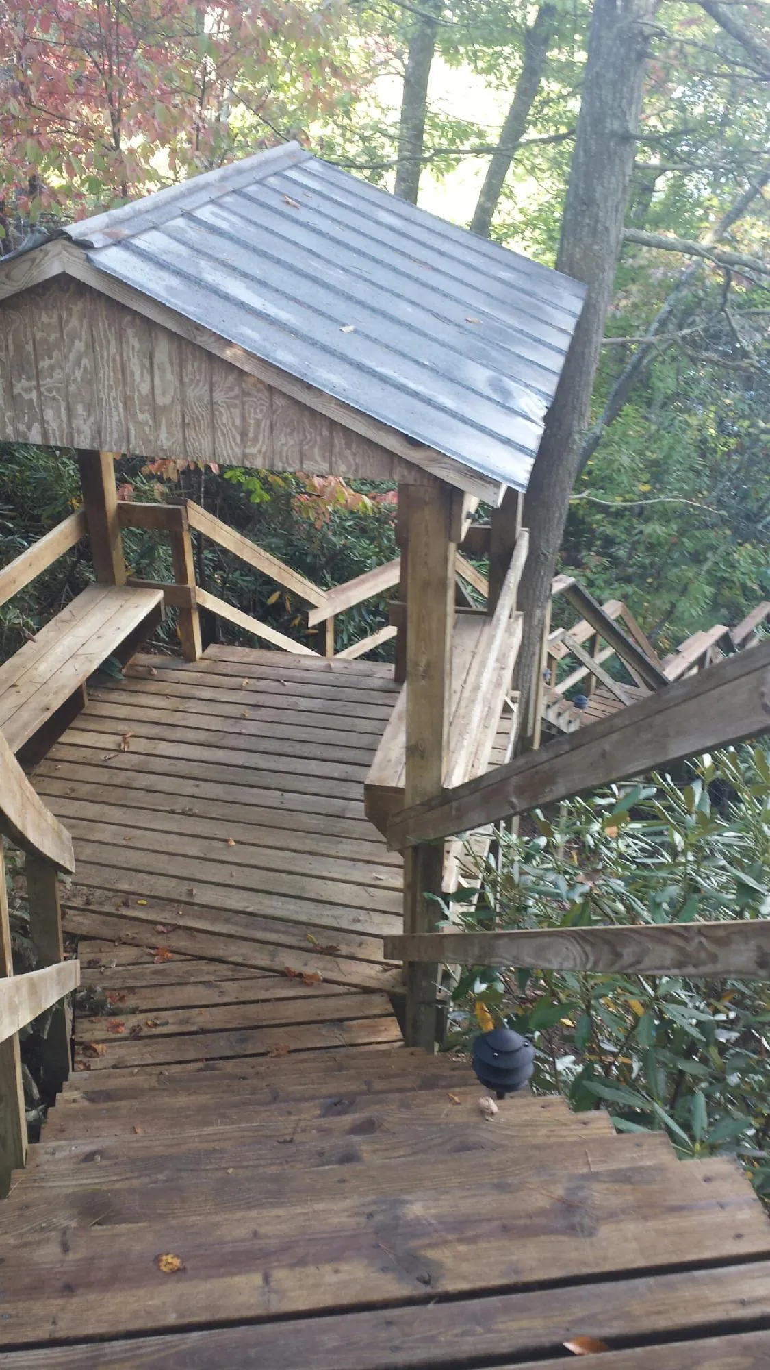 Metal roofed shelter over wooden steps on a wooded walkway — Skylight Repair & Installation work by our crew in Forked River