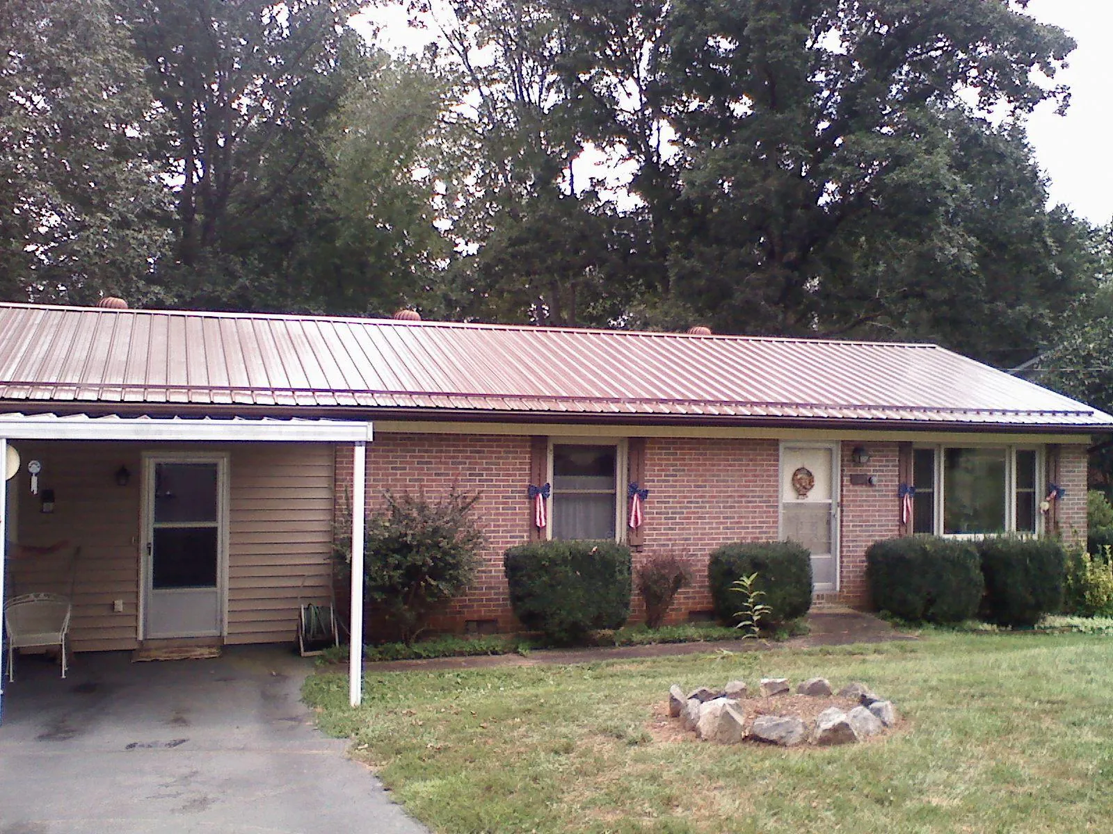 Bronze metal roof and carport on a brick ranch home — Roof Repair work by our crew in Forked River